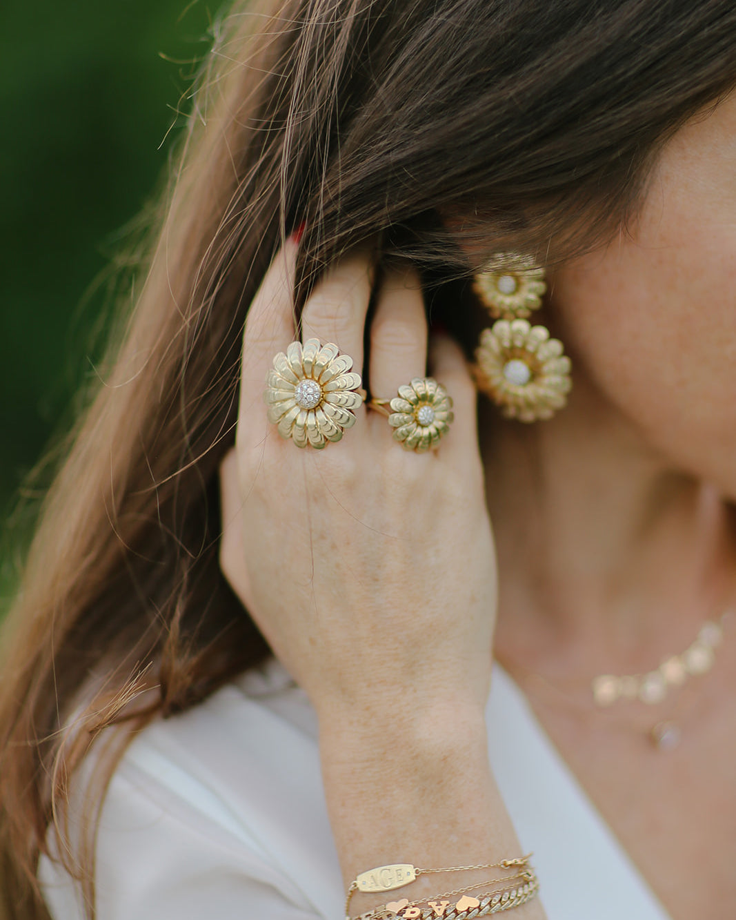 Gold flower rings and bracelets on the hand