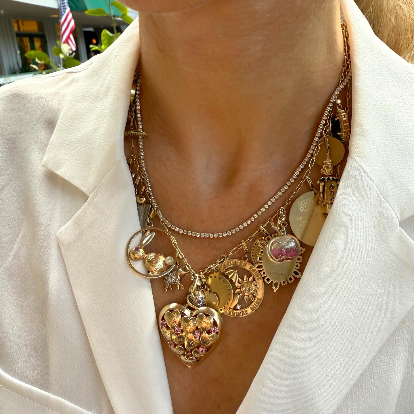 Layered charm necklaces with a white blazer